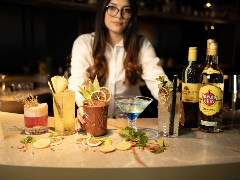 Bartender displaying a variety of coctails at nox bar in voco™ Brussels City North