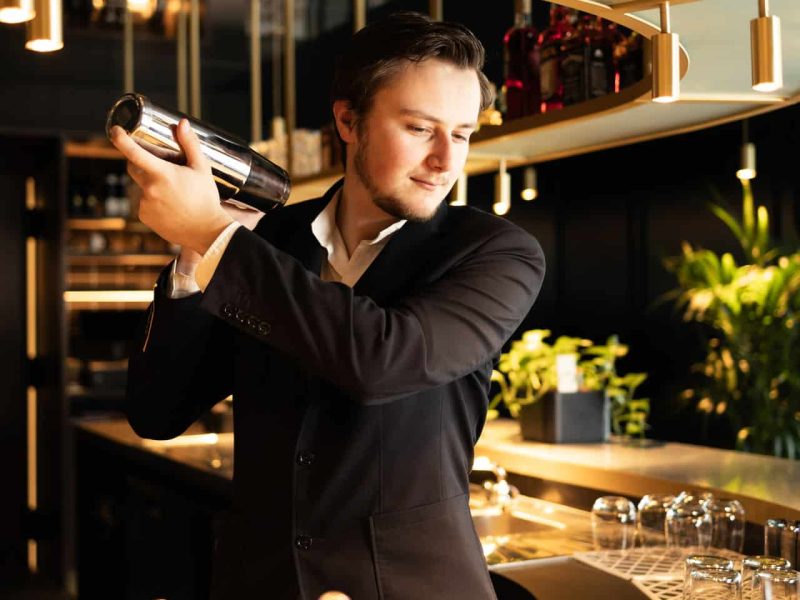 Bartender making a cocktail behind the bar at nox bar in voco™ Brussels City North