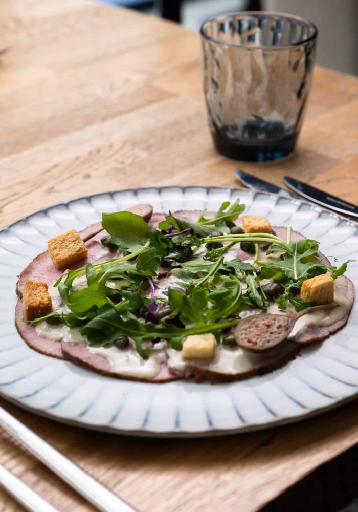 salad on a plate with cutlery and a glass