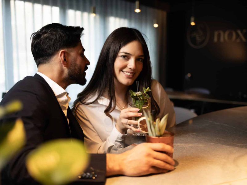 Two patrons enjoying their cocktails at nox bar in voco™ Brussels City North