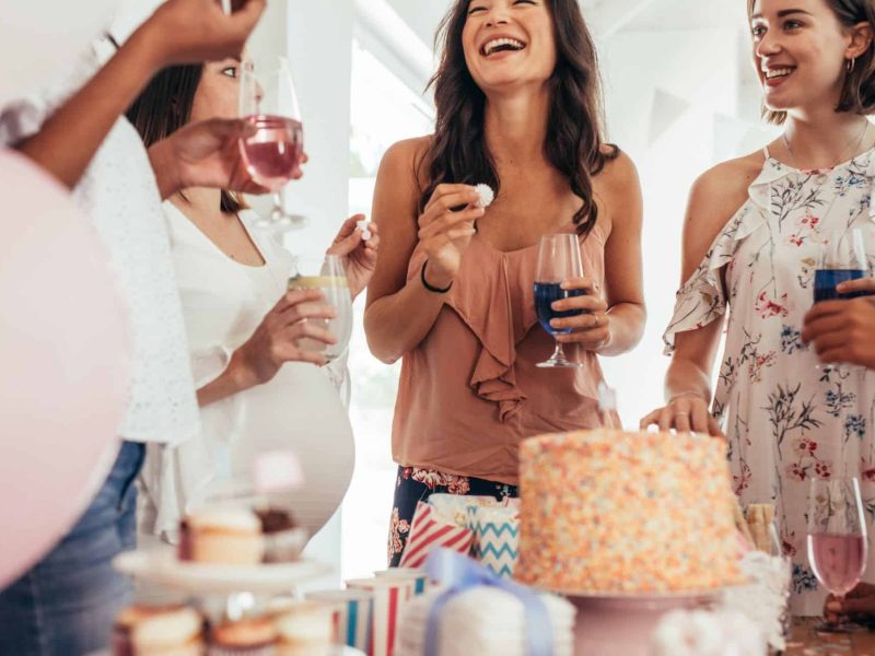 women smiling at a Babyshower women having a drink and snacks n