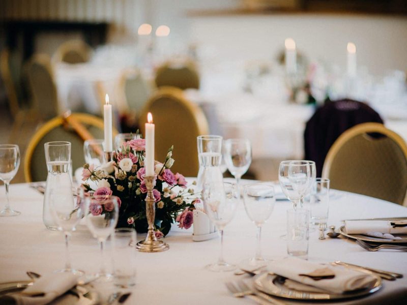 Bridal table setting with pink flowers and a candle