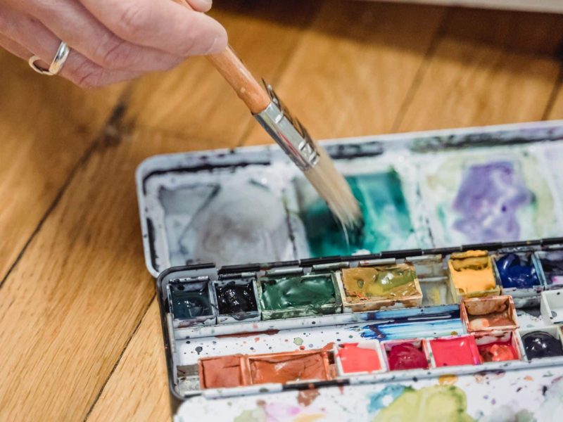 hand grabbing paint with paintbrush